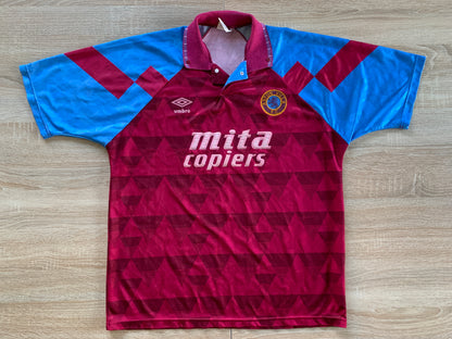 Aston Villa Home Shirt from 1990-1992: The classic home jersey worn by Aston Villa during the 1990-1992 period. Featuring the club's emblem and a traditional design, this shirt captures the essence of the team's representation and efforts on the field during that specific era.